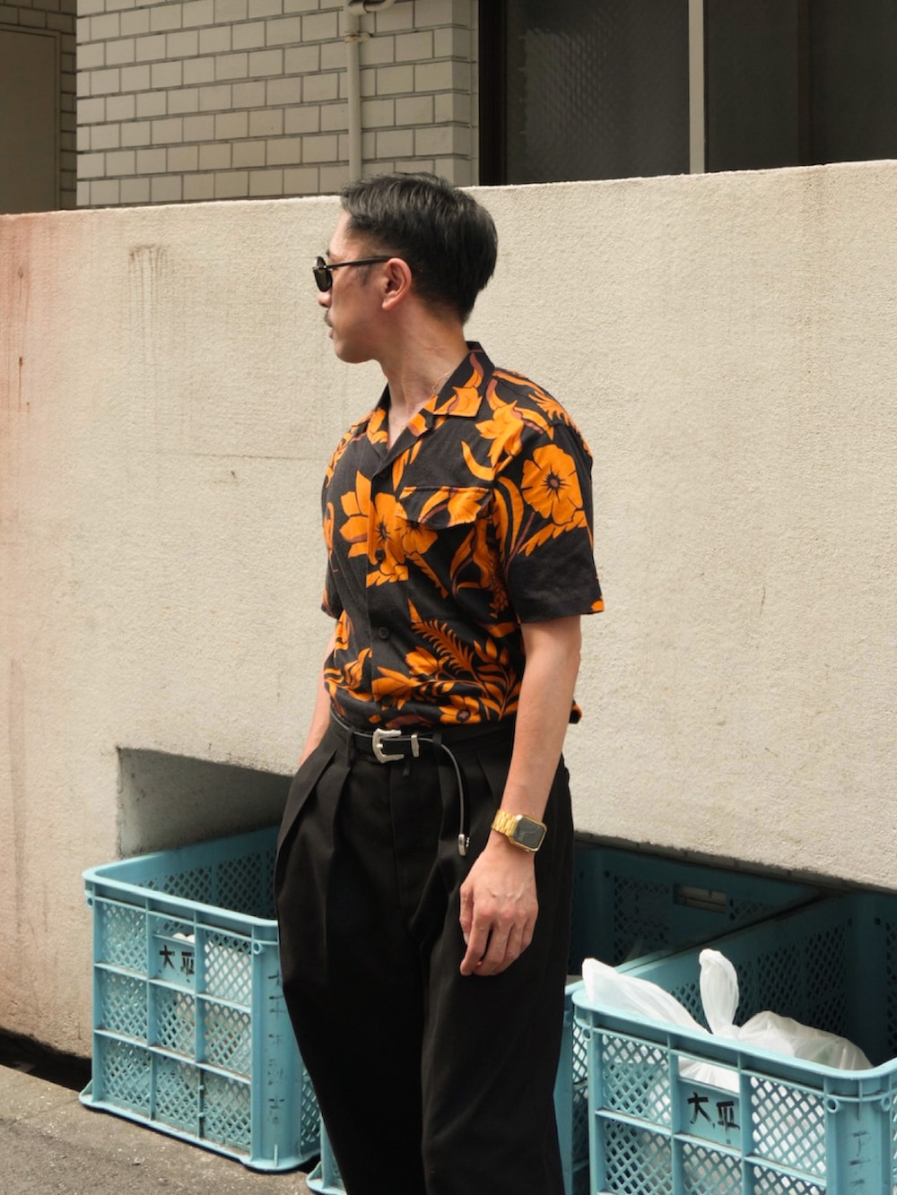 オレンジ系のシャツ/ブラウス、ブラック系のスラックス、ブラック系のベルトを着用したメンズの夏コーディネートの2枚目の写真