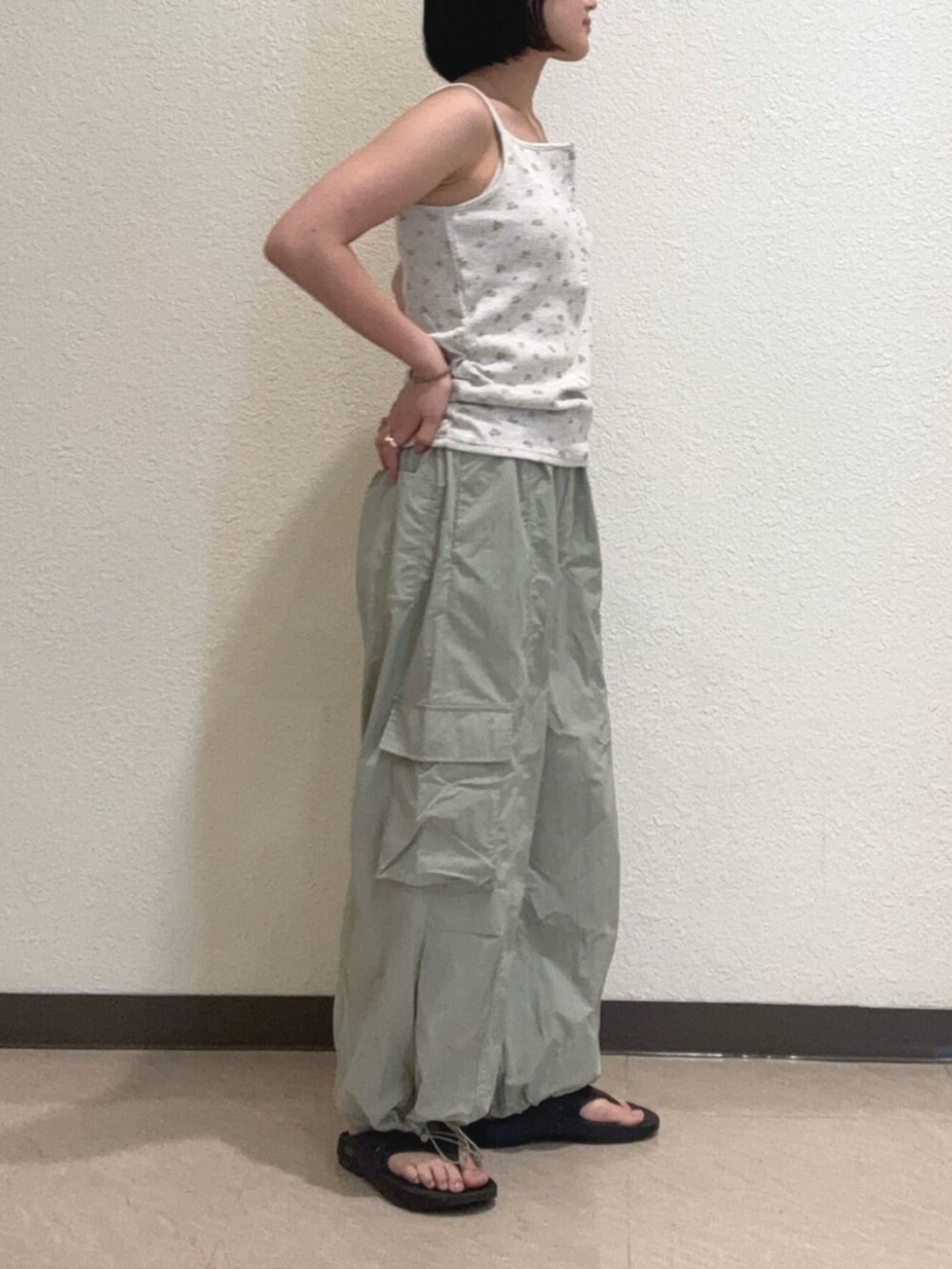 グレー系のキャミソール、グリーン系のその他パンツ、ブルー系のリングを着用したレディースの夏コーディネートの2枚目の写真