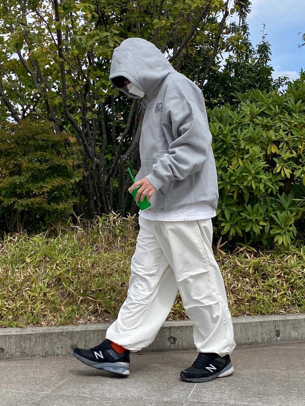 ホワイト系のチノパンツ、ブラック系のスニーカーを着用したメンズの秋コーディネートの2枚目の写真