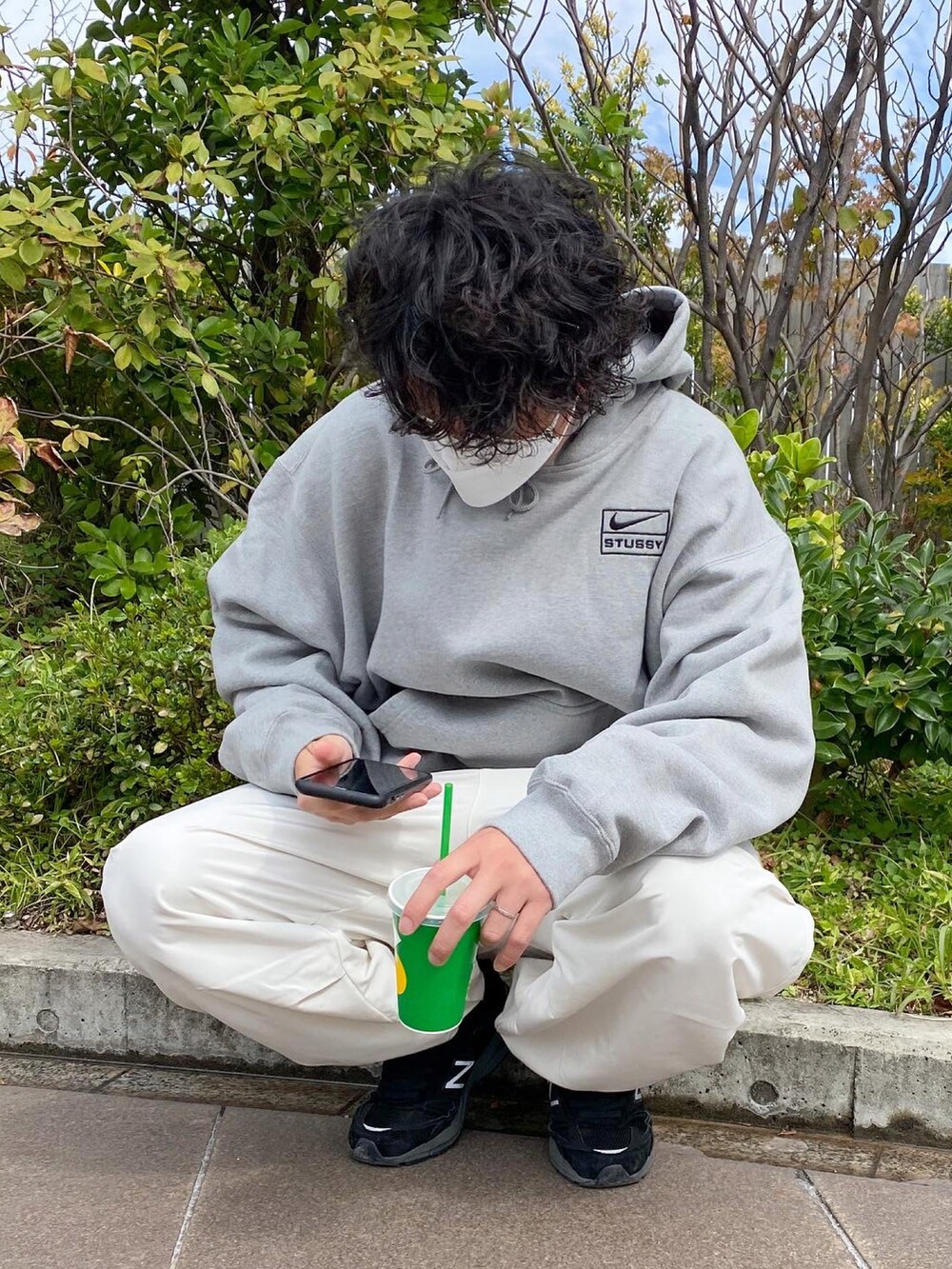 ホワイト系のチノパンツ、ブラック系のスニーカーを着用したメンズの秋コーディネートの3枚目の写真