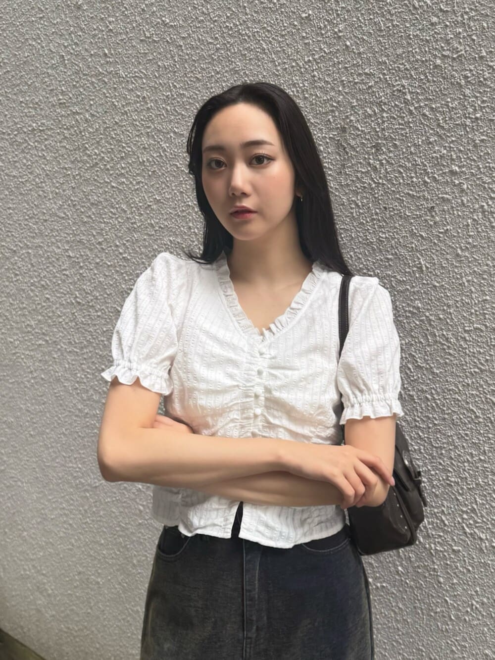 グリーン系のデニムパンツ、ブラウン系のブーツ、ブラック系のハンドバッグを着用したレディースの秋コーディネートの7枚目の写真
