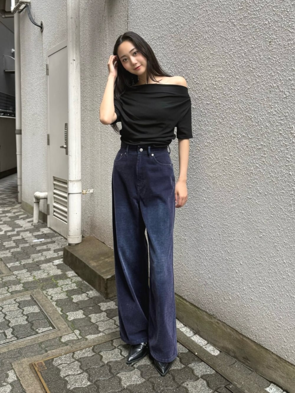 ブラック系のハンドバッグ、パープル系のデニムパンツ、ブラック系のパンプスを着用したレディースの夏コーディネートの4枚目の写真