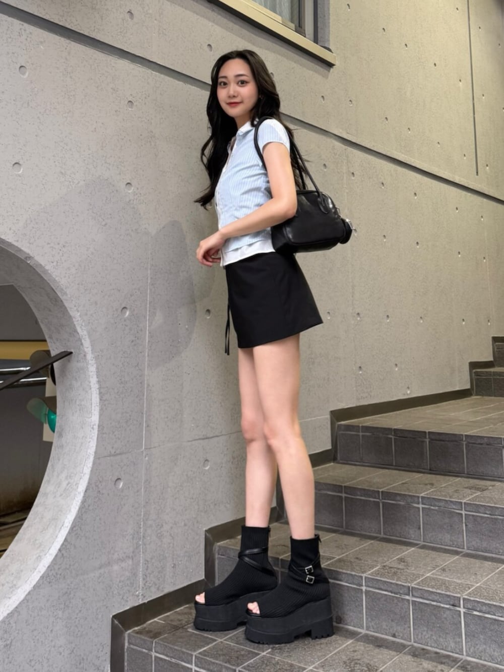 ブルー系のシャツ/ブラウス、ブラック系のショルダーバッグ、ブラック系のスカートを着用したレディースの夏コーディネートの3枚目の写真