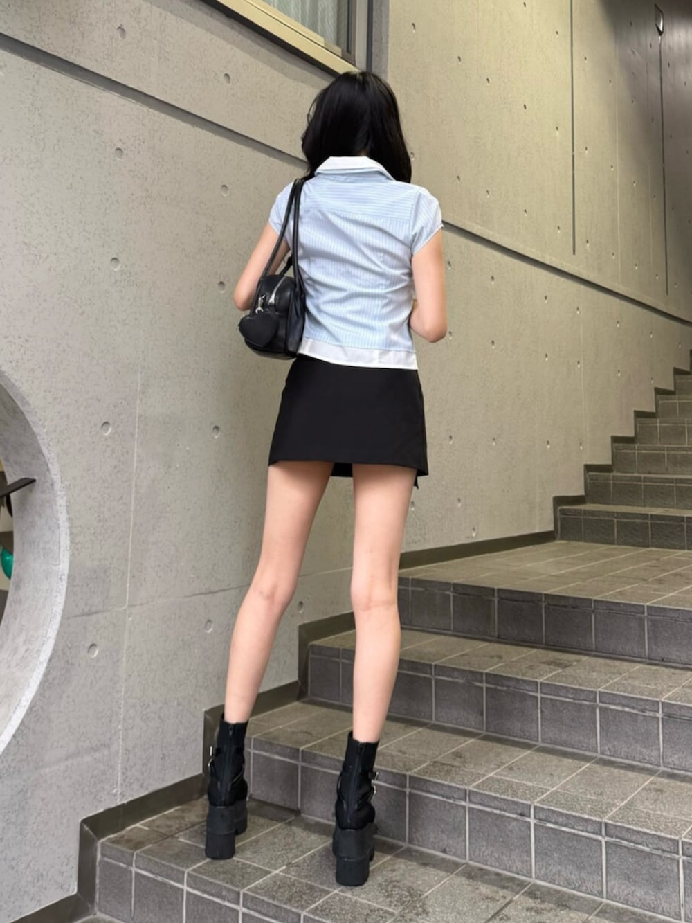 ブルー系のシャツ/ブラウス、ブラック系のショルダーバッグ、ブラック系のスカートを着用したレディースの夏コーディネートの4枚目の写真