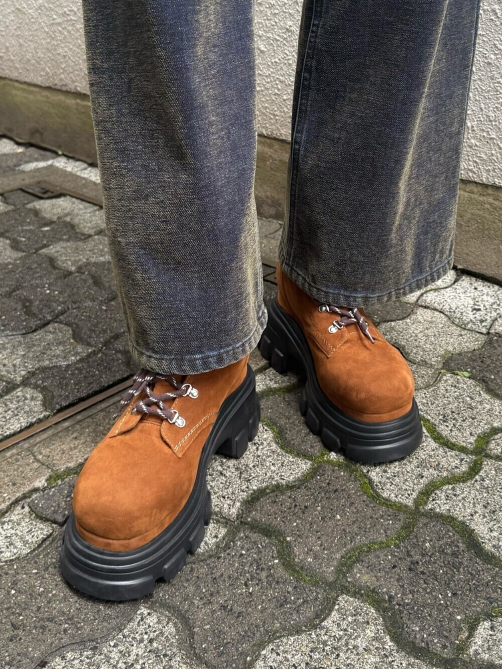 グリーン系のデニムパンツ、ブラウン系のブーツ、ブラック系のハンドバッグを着用したレディースの秋コーディネートの9枚目の写真