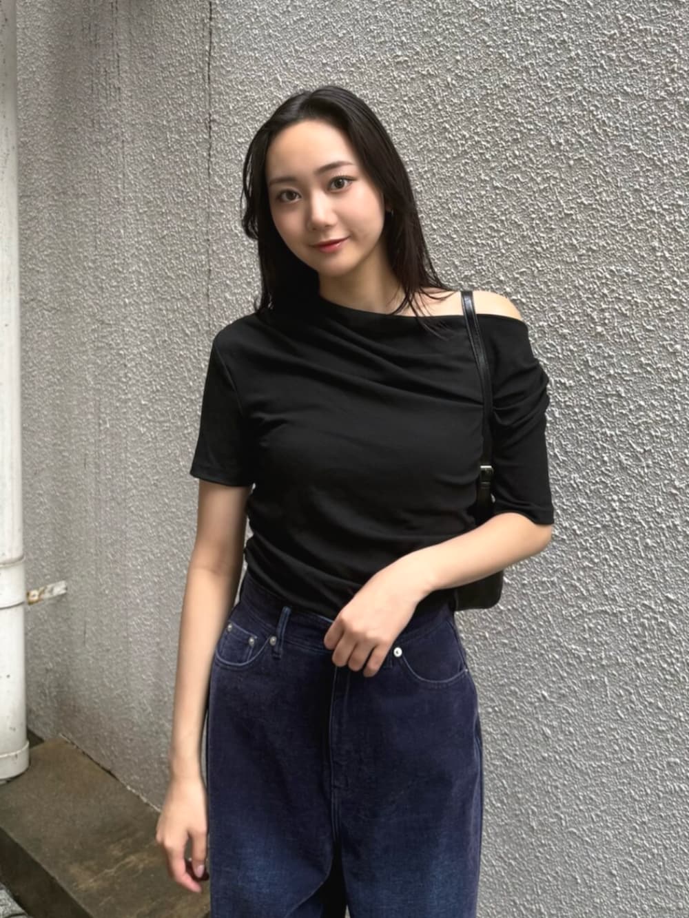ブラック系のハンドバッグ、パープル系のデニムパンツ、ブラック系のパンプスを着用したレディースの夏コーディネートの6枚目の写真