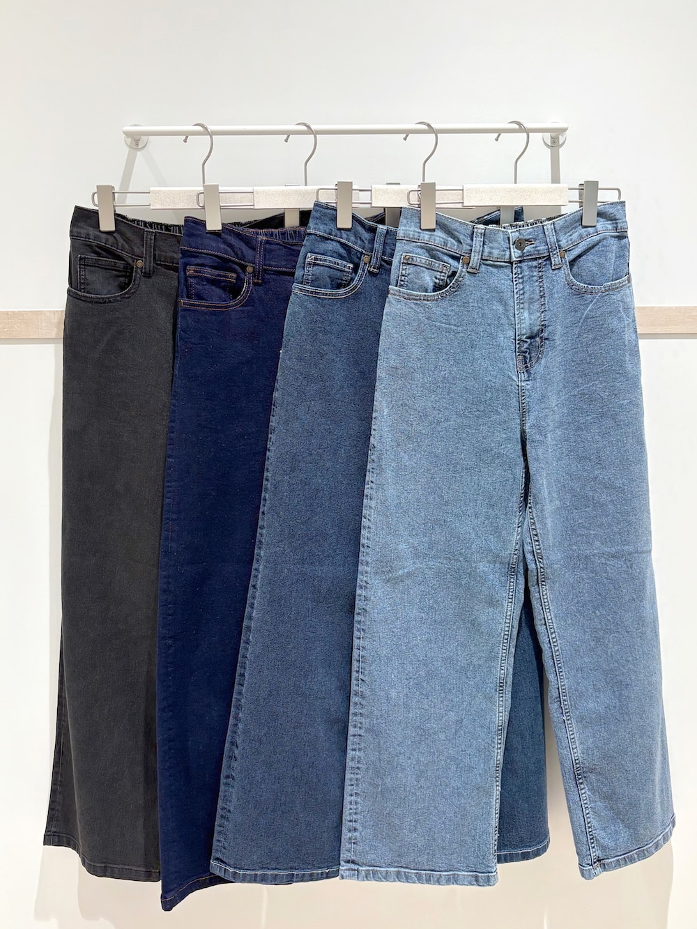 ホワイト系のカーディガン/ボレロ、ゴールド系のタンクトップ、ブルー系のデニムパンツを着用したレディースの秋コーディネートの5枚目の写真