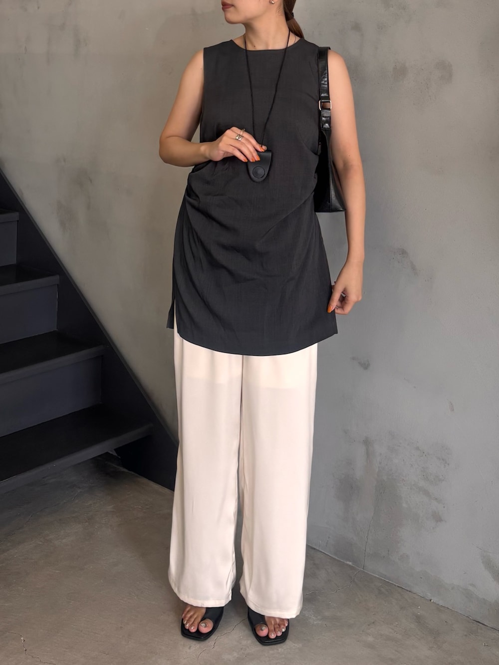 グレー系のシャツ/ブラウス、ホワイト系のその他パンツ、ブラック系のハンドバッグを着用したレディースの夏コーディネートの4枚目の写真