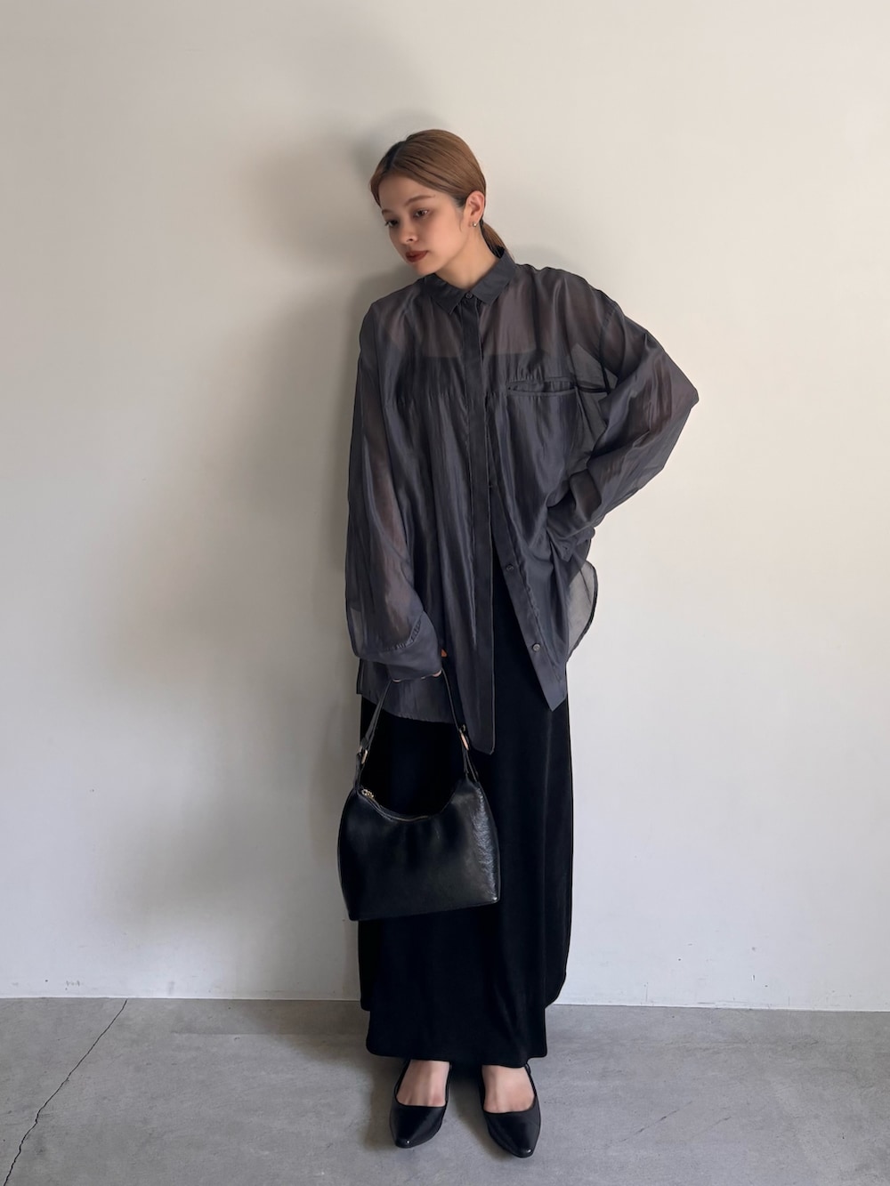 ブラック系のシャツ/ブラウス、ブラック系のスカート、ブラック系のハンドバッグを着用したレディースの夏コーディネートの2枚目の写真