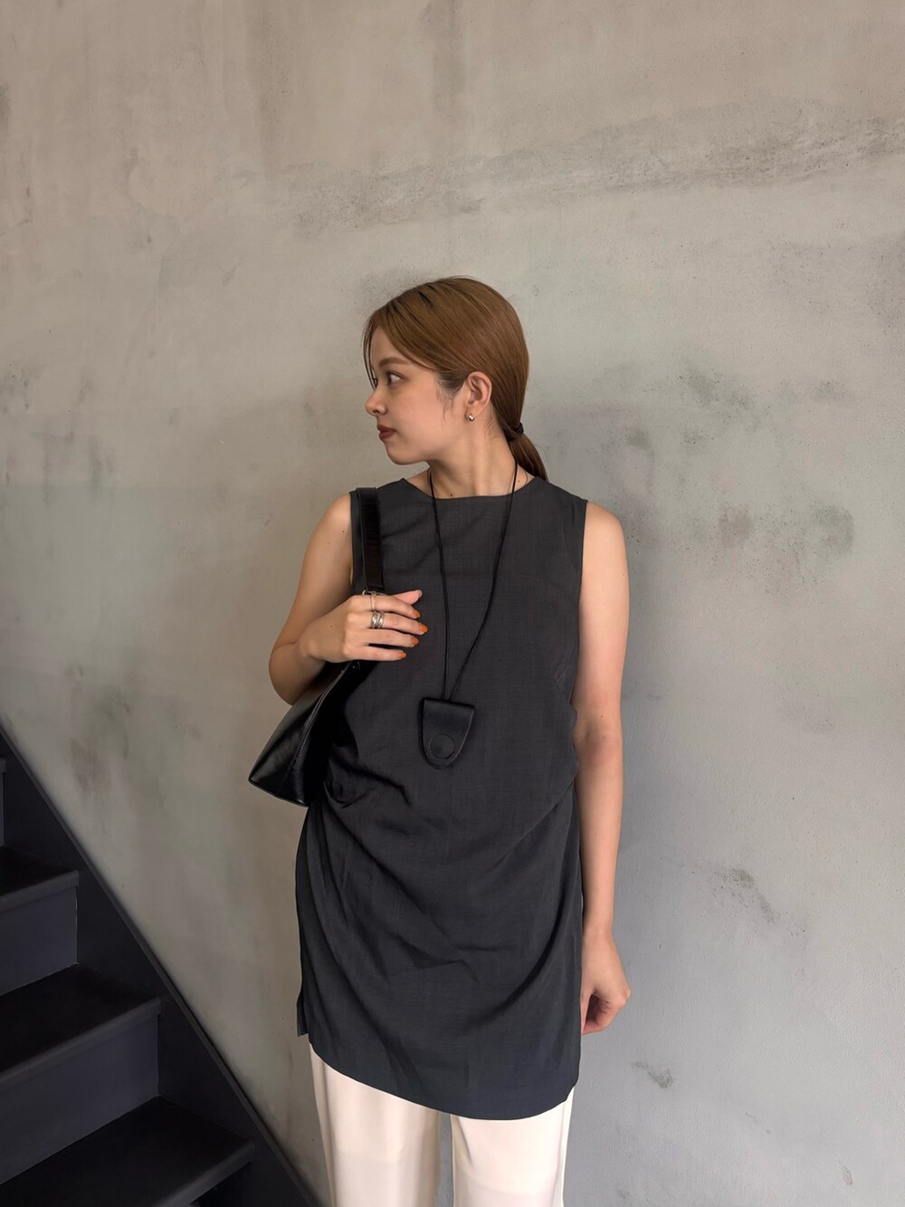 グレー系のシャツ/ブラウス、ホワイト系のその他パンツ、ブラック系のハンドバッグを着用したレディースの夏コーディネートの2枚目の写真