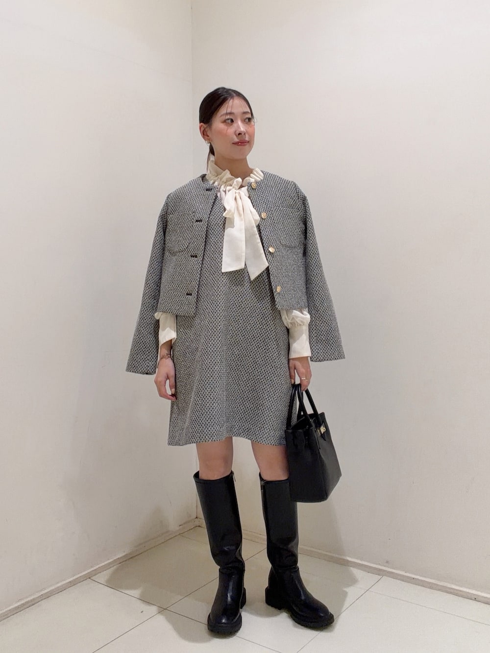ブラック系のワンピース、ホワイト系のシャツ/ブラウス、ブラック系のブーツを着用したレディースの夏コーディネートの3枚目の写真