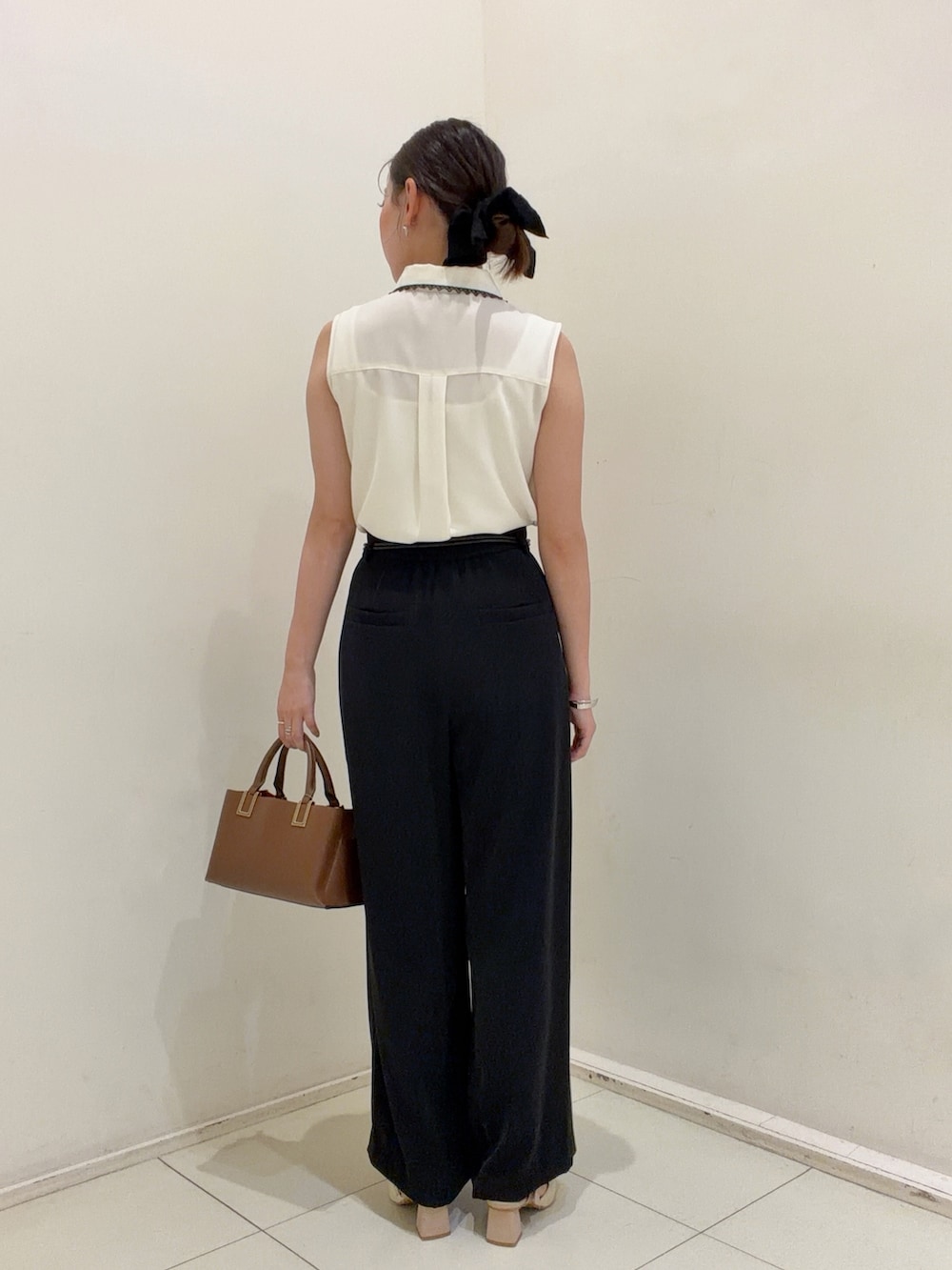 ブラック系のその他パンツ、ホワイト系のシャツ/ブラウス、ブラウン系のトートバッグを着用したレディースの夏コーディネートの3枚目の写真
