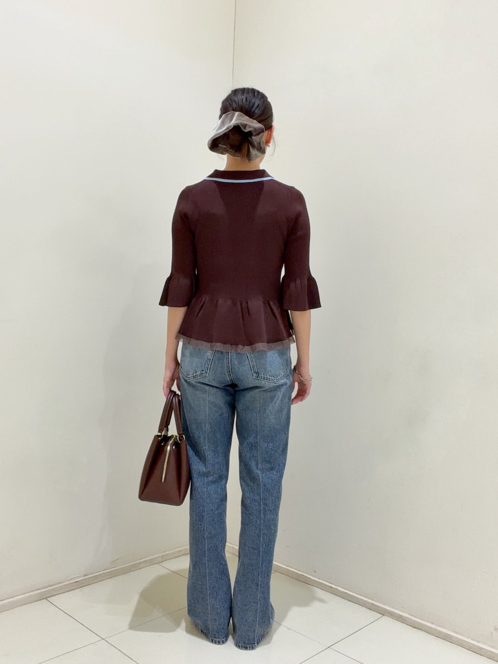 ブラウン系のニット/セーター、ブルー系のその他パンツ、レッド系のトートバッグを着用したレディースの夏コーディネートの3枚目の写真