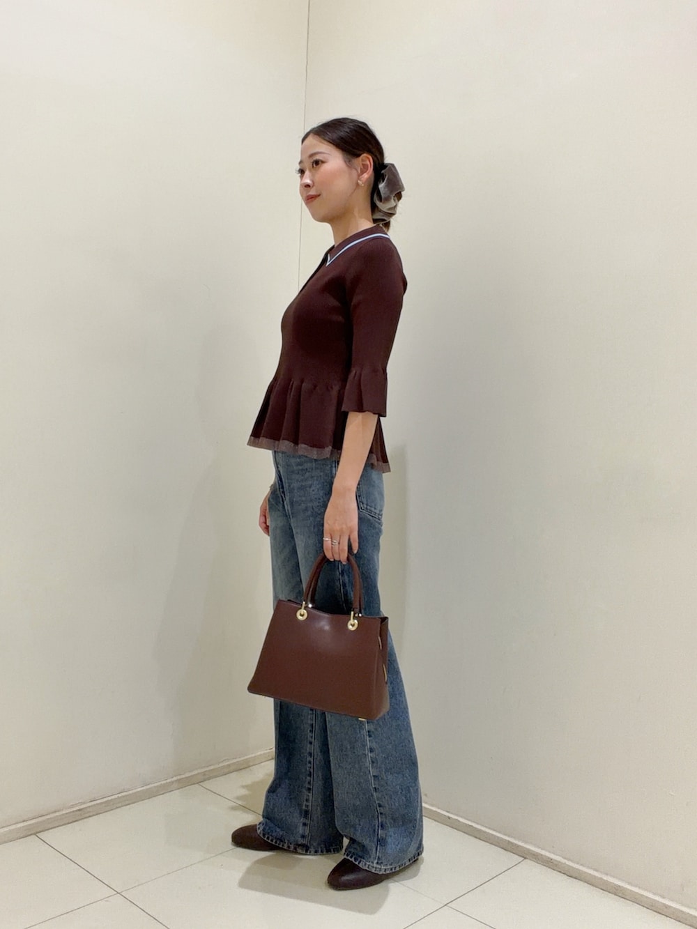 ブラウン系のニット/セーター、ブルー系のその他パンツ、レッド系のトートバッグを着用したレディースの夏コーディネートの2枚目の写真
