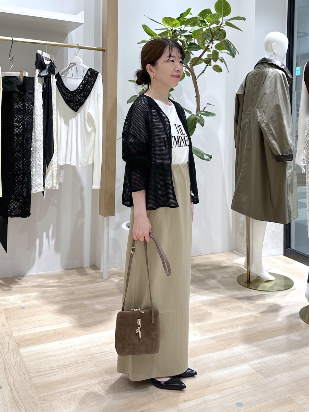 ベージュ系のスカート、ブラック系のパンプス、ブラウン系のショルダーバッグを着用したレディースの夏コーディネートの3枚目の写真