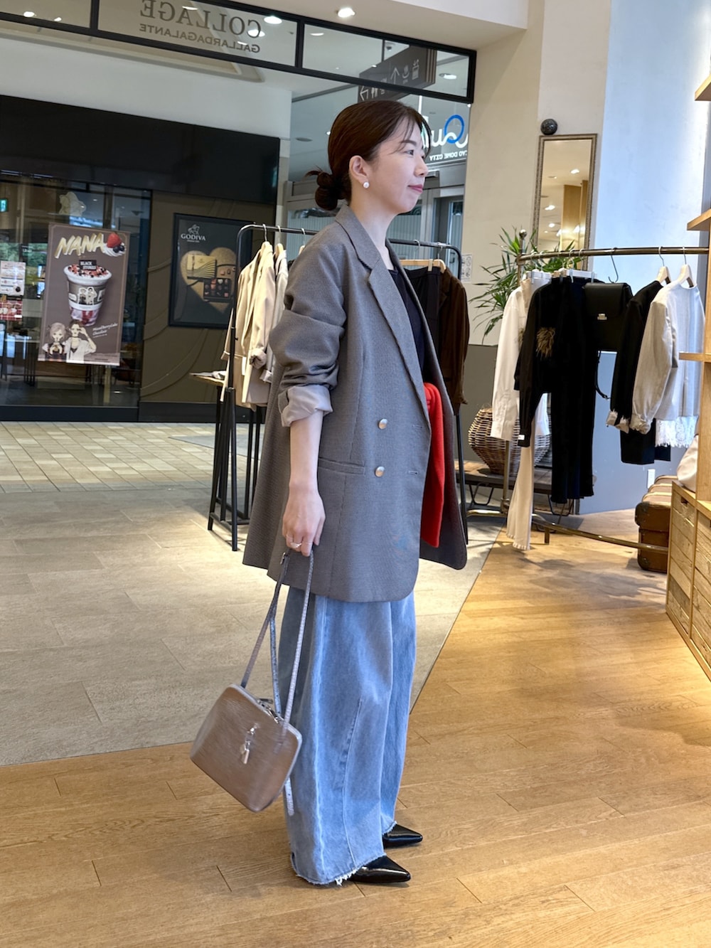 ブルー系のデニムパンツ、ブラック系のパンプス、レッド系のニット/セーターを着用したレディースの秋コーディネートの3枚目の写真