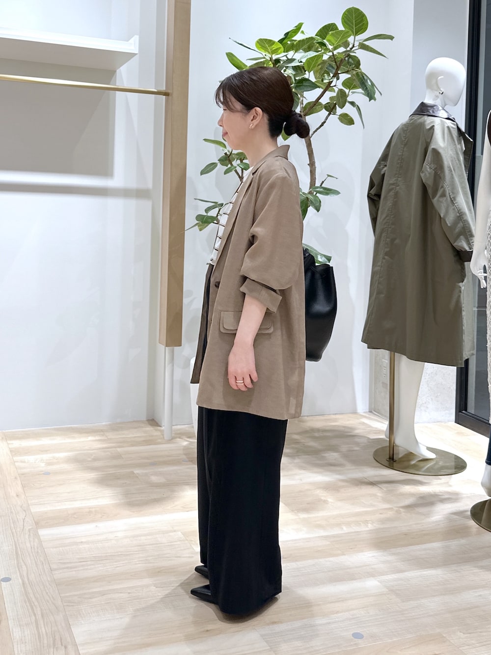 ブラック系のパンプス、ブラック系のスラックス、ベージュ系のテーラードジャケットを着用したレディースの夏コーディネートの3枚目の写真