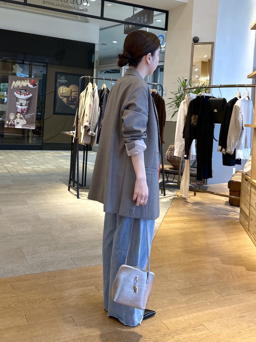 ブルー系のデニムパンツ、ブラック系のパンプス、レッド系のニット/セーターを着用したレディースの秋コーディネートの4枚目の写真