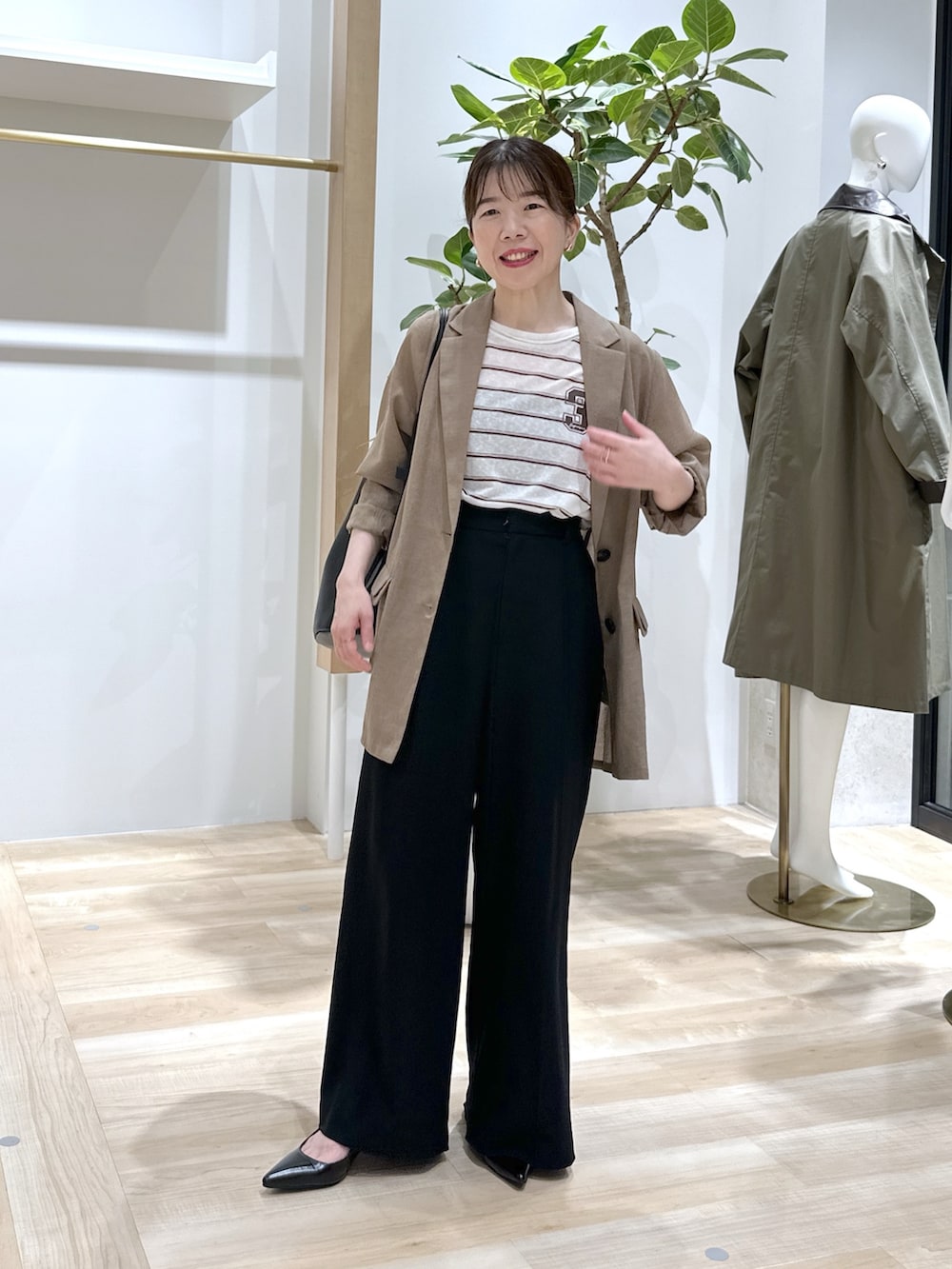 ブラック系のパンプス、ブラック系のスラックス、ベージュ系のテーラードジャケットを着用したレディースの夏コーディネートの5枚目の写真
