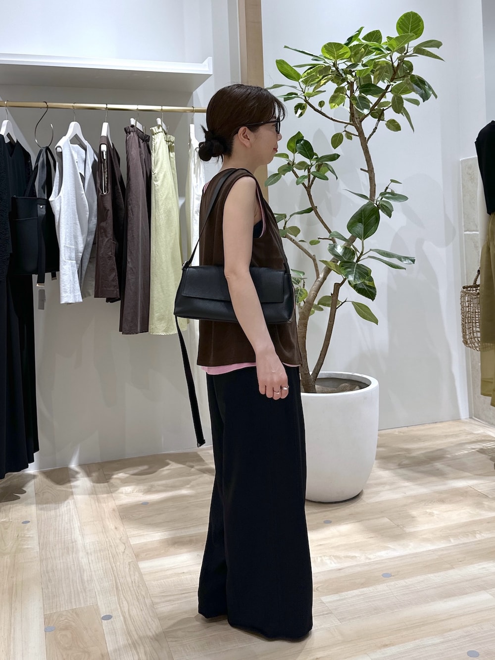 ブラック系のスラックス、ピンク系のタンクトップ、ブラウン系のタンクトップを着用したレディースの夏コーディネートの3枚目の写真