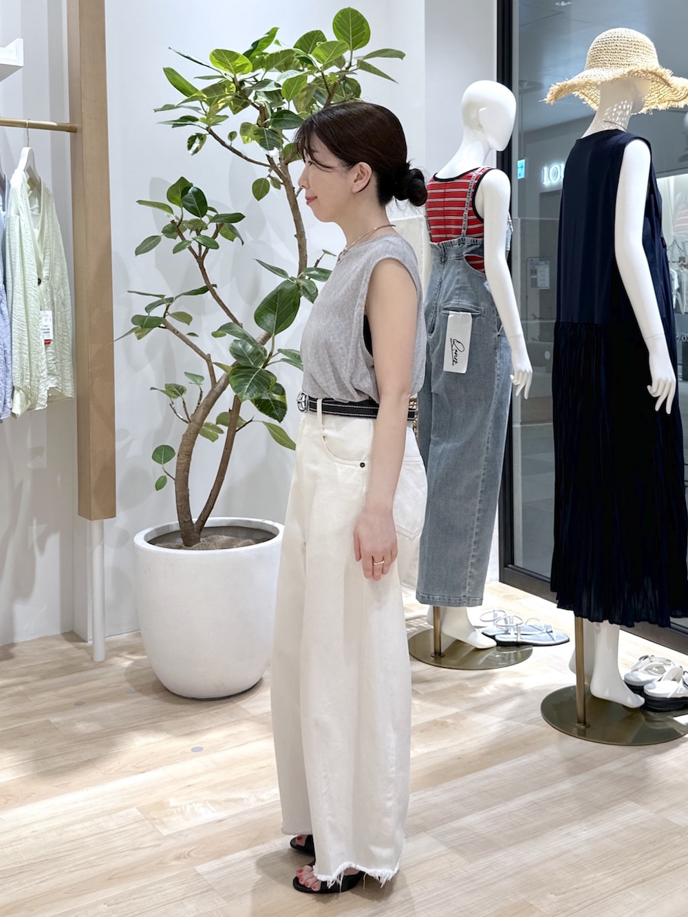 ブラック系のサンダル、ブルー系のショルダーバッグ、ホワイト系のデニムパンツを着用したレディースの夏コーディネートの3枚目の写真