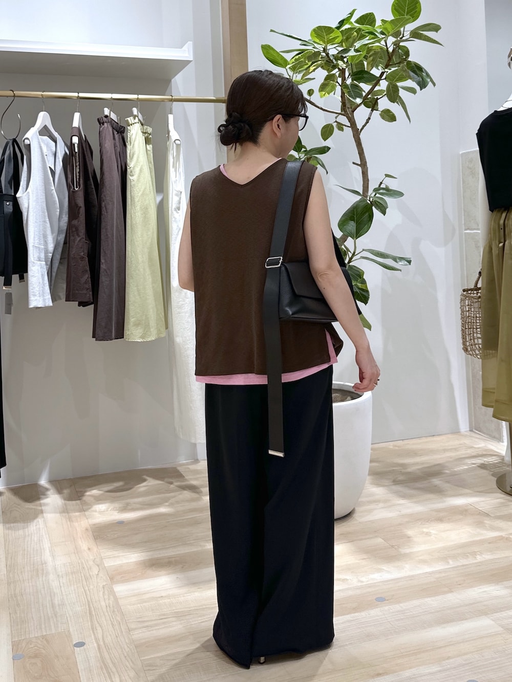 ブラック系のスラックス、ピンク系のタンクトップ、ブラウン系のタンクトップを着用したレディースの夏コーディネートの5枚目の写真
