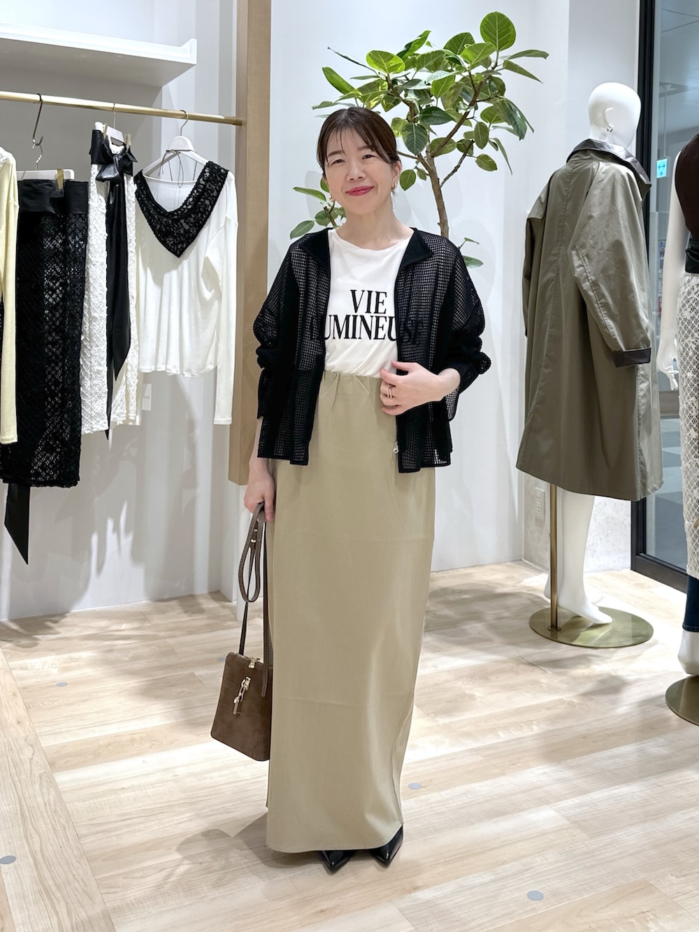 ベージュ系のスカート、ブラック系のパンプス、ブラウン系のショルダーバッグを着用したレディースの夏コーディネートの6枚目の写真