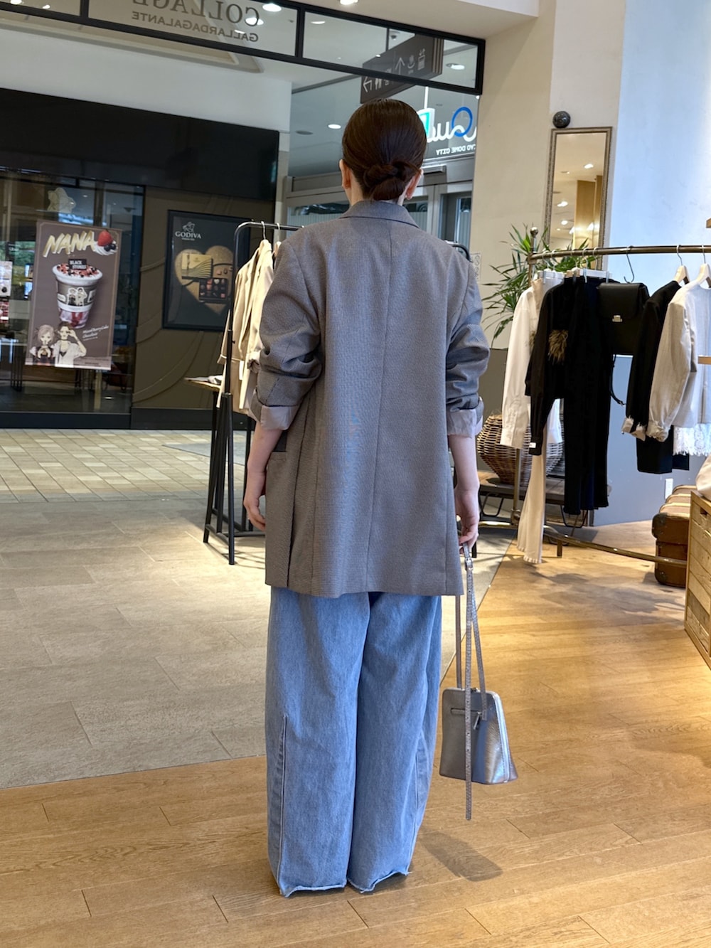 ブルー系のデニムパンツ、ブラック系のパンプス、レッド系のニット/セーターを着用したレディースの秋コーディネートの6枚目の写真
