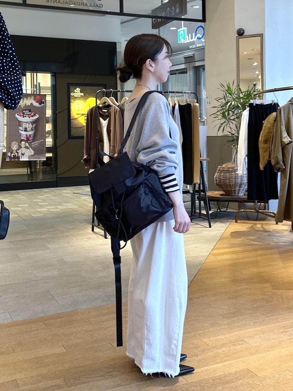 ブラック系のパンプス、ホワイト系のデニムパンツ、グレー系のニット/セーターを着用したレディースの秋コーディネートの5枚目の写真