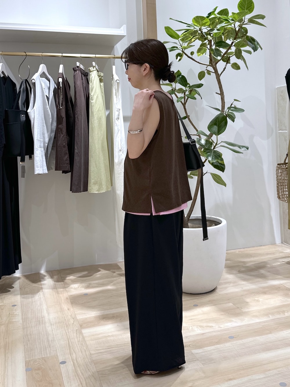 ブラック系のスラックス、ピンク系のタンクトップ、ブラウン系のタンクトップを着用したレディースの夏コーディネートの4枚目の写真