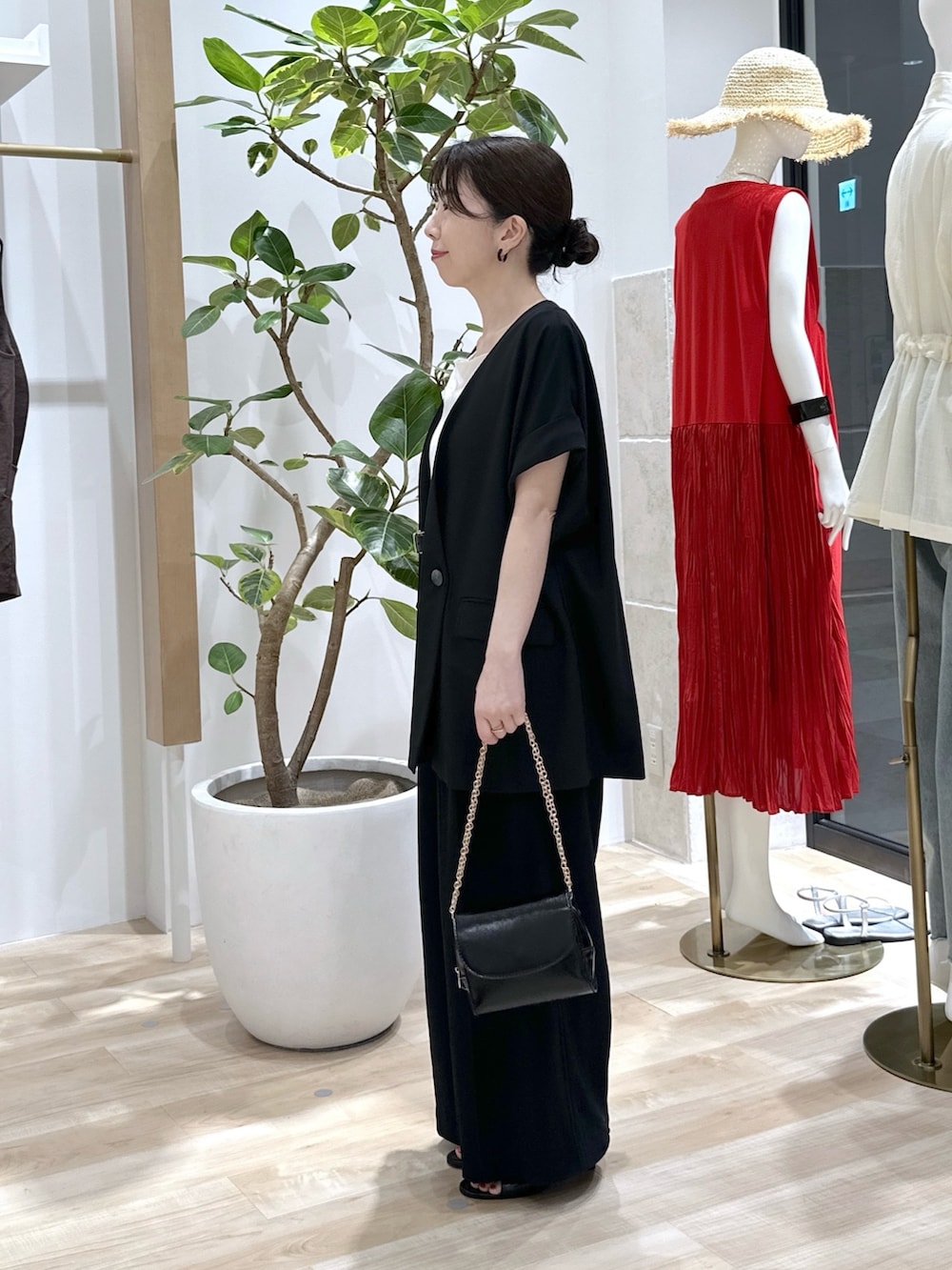 ブラック系のサンダル、ブラック系のショルダーバッグ、ブラック系のスラックスを着用したレディースの夏コーディネートの3枚目の写真