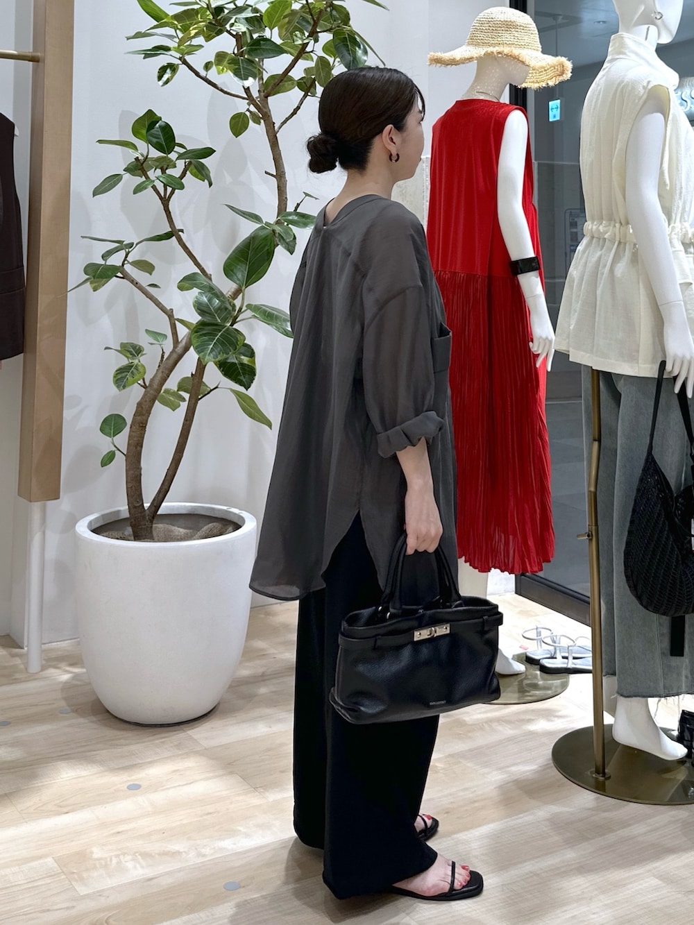 ブラック系のサンダル、ブラック系のスラックス、ブラック系のトートバッグを着用したレディースの夏コーディネートの4枚目の写真