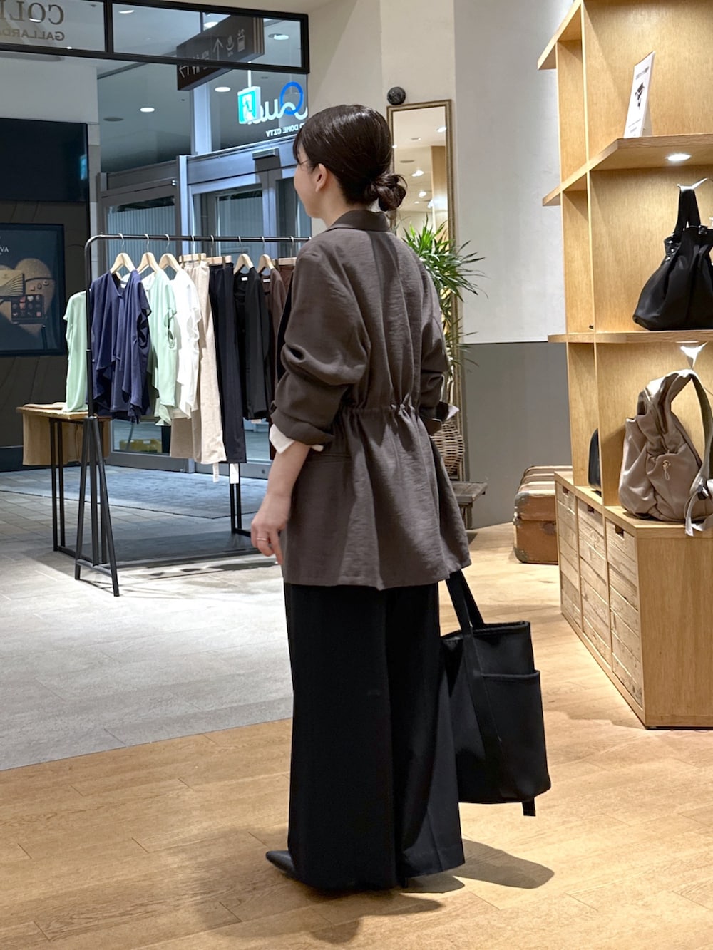 ブラック系のスラックス、ブラック系のパンプス、ブラック系のトートバッグを着用したレディースの秋コーディネートの4枚目の写真