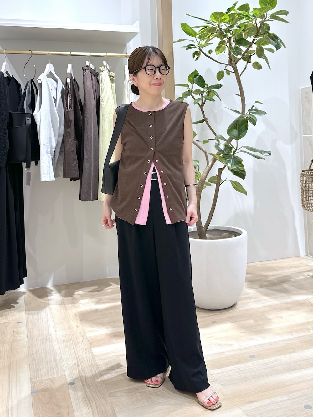 ブラック系のスラックス、ピンク系のタンクトップ、ブラウン系のタンクトップを着用したレディースの夏コーディネートの2枚目の写真