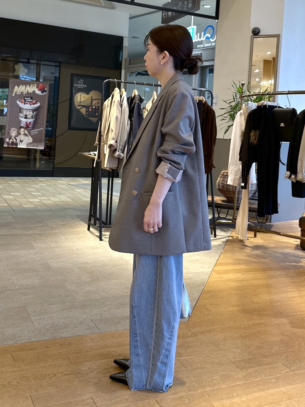 ブルー系のデニムパンツ、ブラック系のパンプス、レッド系のニット/セーターを着用したレディースの秋コーディネートの5枚目の写真