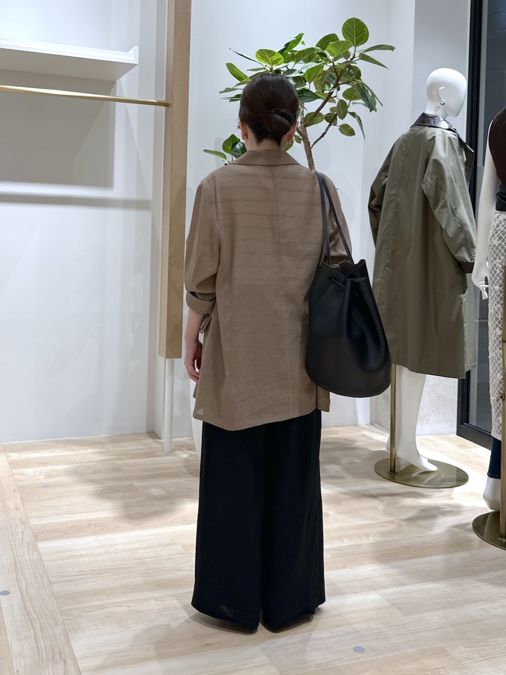 ブラック系のパンプス、ブラック系のスラックス、ベージュ系のテーラードジャケットを着用したレディースの夏コーディネートの4枚目の写真