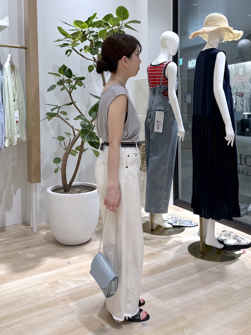 ブラック系のサンダル、ブルー系のショルダーバッグ、ホワイト系のデニムパンツを着用したレディースの夏コーディネートの4枚目の写真