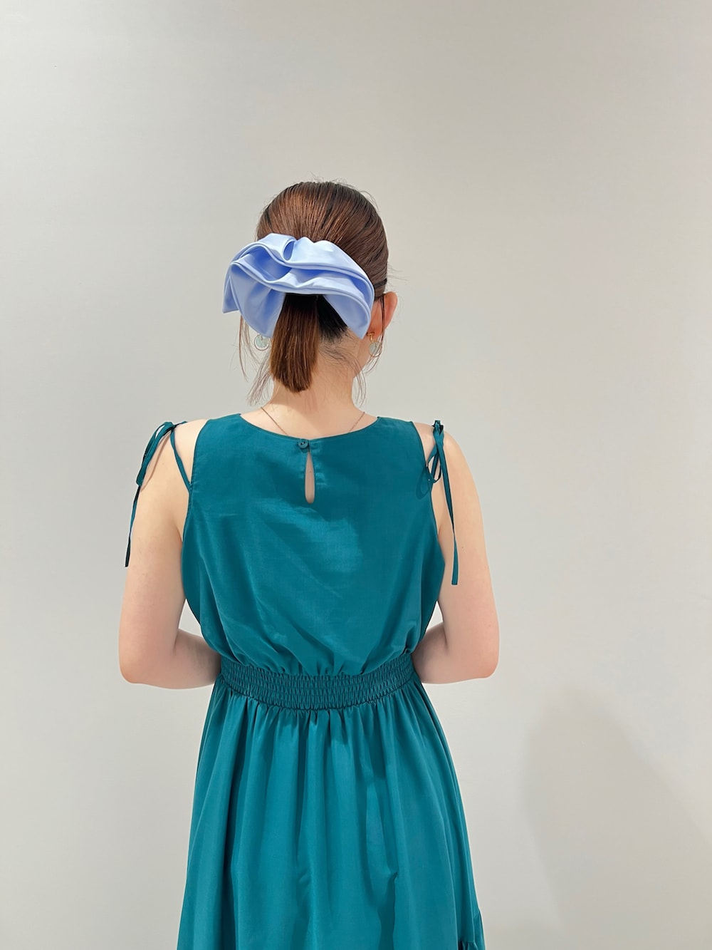 ベージュ系のトートバッグ、グリーン系のワンピースを着用したレディースの夏コーディネートの5枚目の写真
