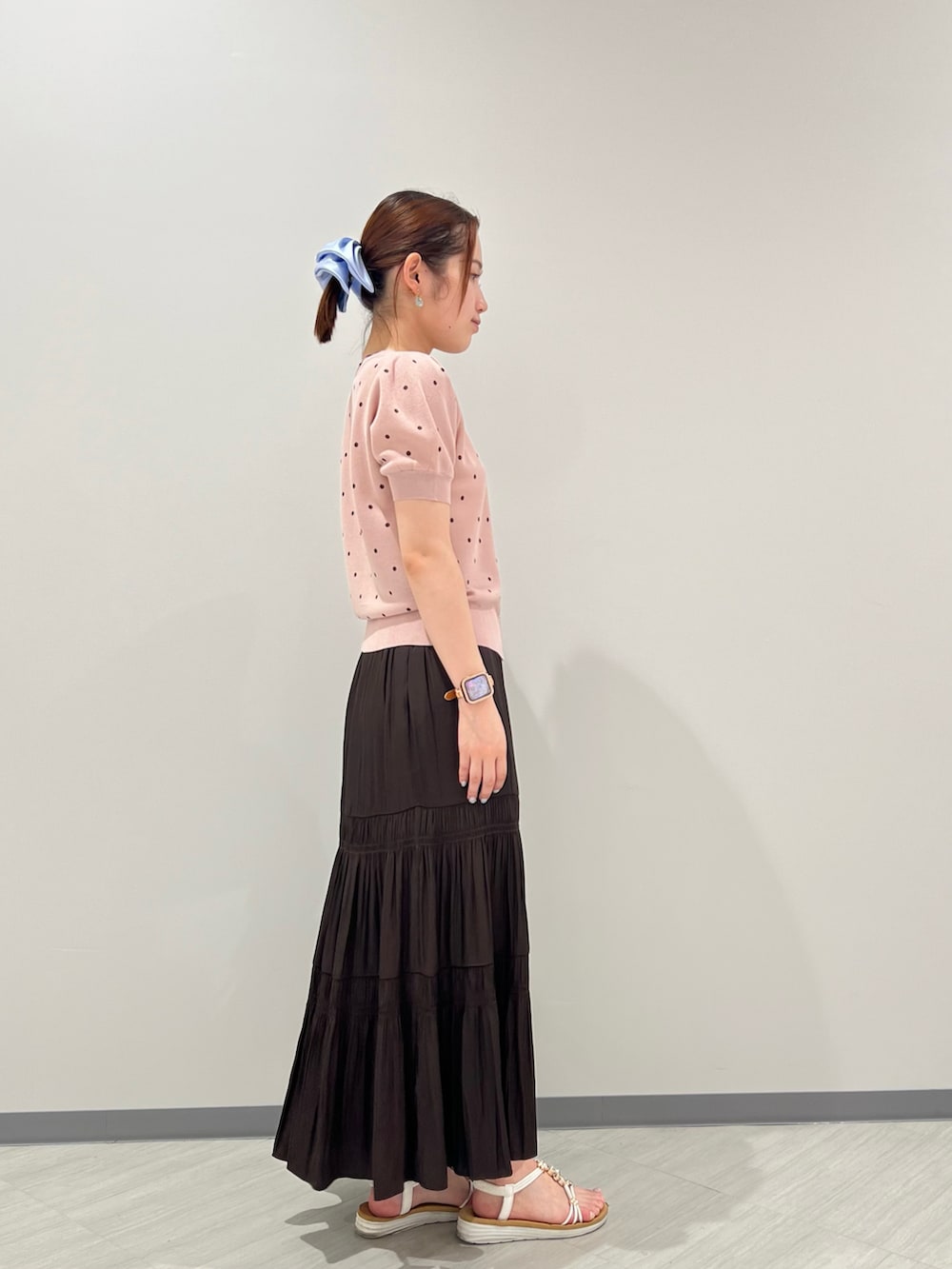ピンク系のカーディガン/ボレロ、ブラウン系のスカート、ブラウン系のボストンバッグを着用したレディースの夏コーディネートの2枚目の写真