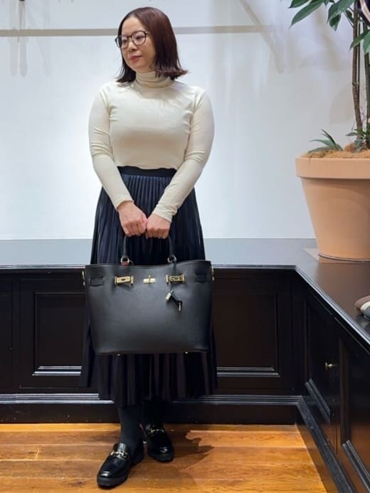 ブラック系のノーカラージャケット、ホワイト系のTシャツ/カットソー、ブルー系のスカートを着用したレディースの冬コーディネートの9枚目の写真