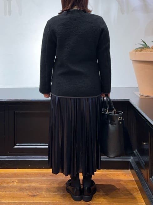 ブラック系のノーカラージャケット、ホワイト系のTシャツ/カットソー、ブルー系のスカートを着用したレディースの冬コーディネートの7枚目の写真
