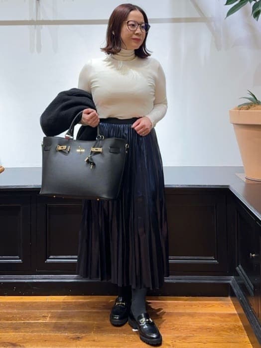 ブラック系のノーカラージャケット、ホワイト系のTシャツ/カットソー、ブルー系のスカートを着用したレディースの冬コーディネートの8枚目の写真