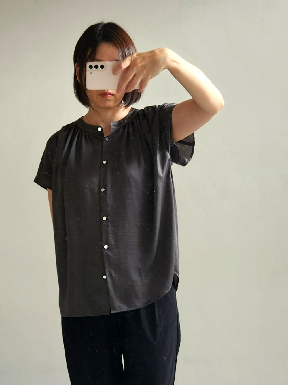 ブラック系のスラックス、グレー系のシャツ/ブラウスを着用したレディースの春コーディネートの2枚目の写真
