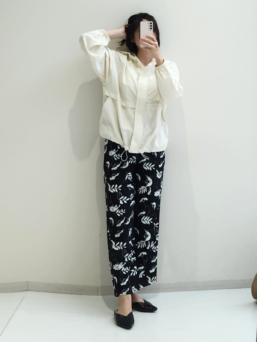ベージュ系のパンツ、ホワイト系のパーカー、ホワイト系のタンクトップを着用したレディースの春コーディネートの2枚目の写真