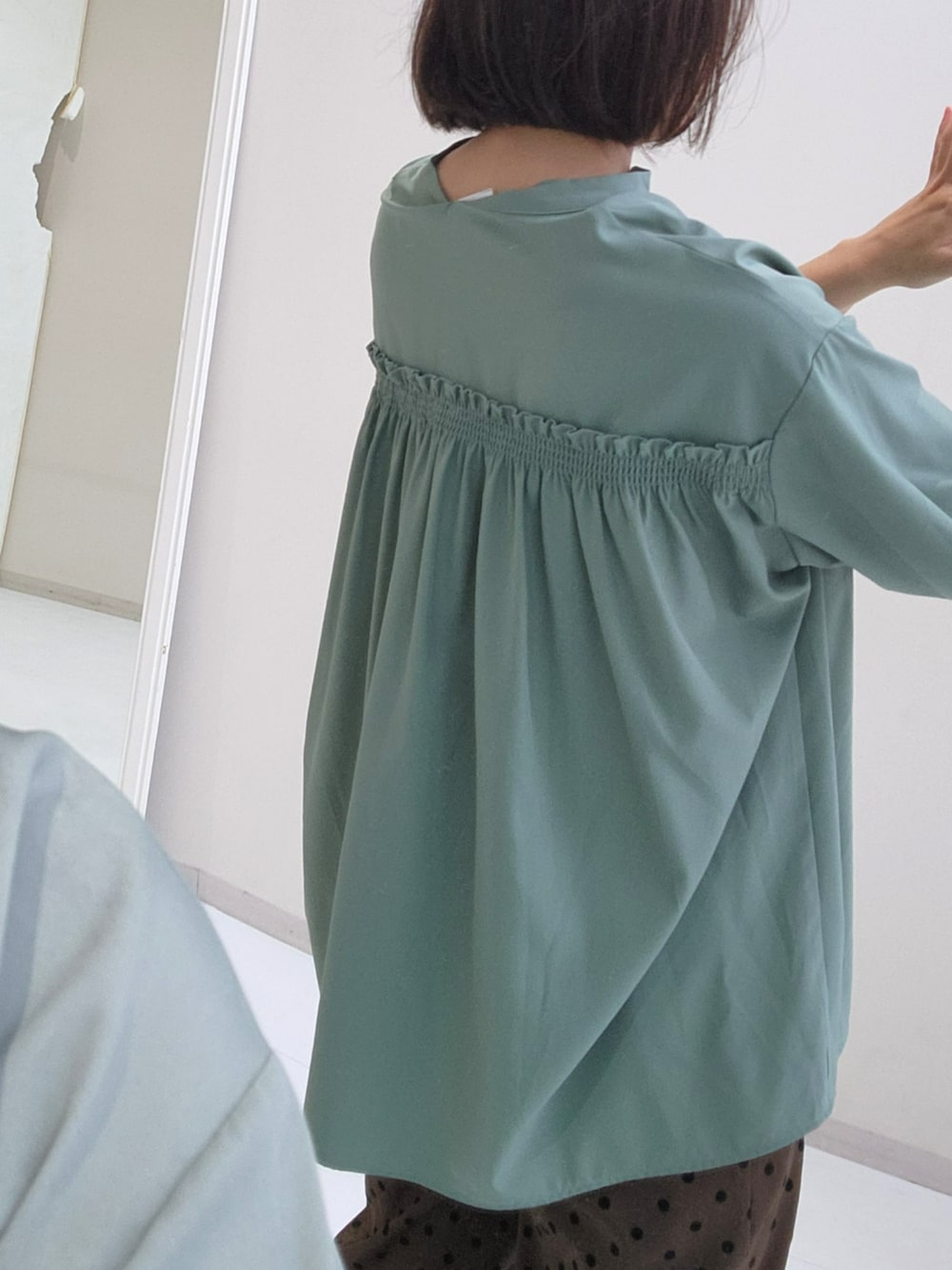ブラウン系のパンツ、グリーン系のシャツ/ブラウスを着用したレディースの秋コーディネートの3枚目の写真