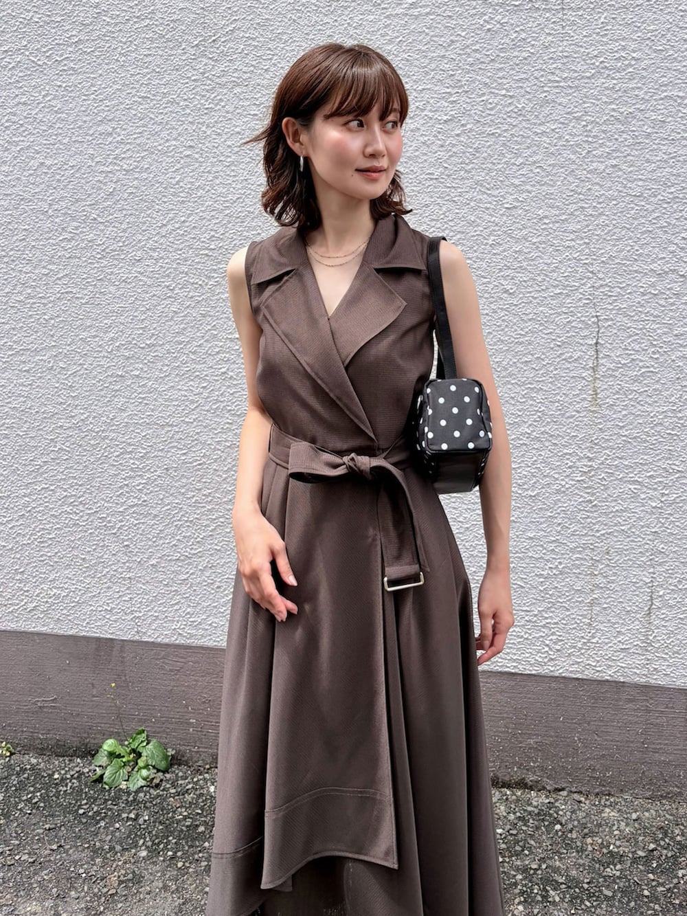 ブラウン系のワンピース、グレー系のベスト、シルバー系のピアス（両耳用）を着用したレディースの夏コーディネートの5枚目の写真
