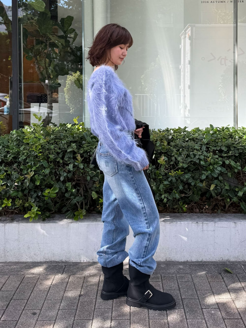 ブルー系のニット/セーター、ブラック系のブルゾン、ブルー系のデニムパンツを着用したレディースの秋コーディネートの2枚目の写真