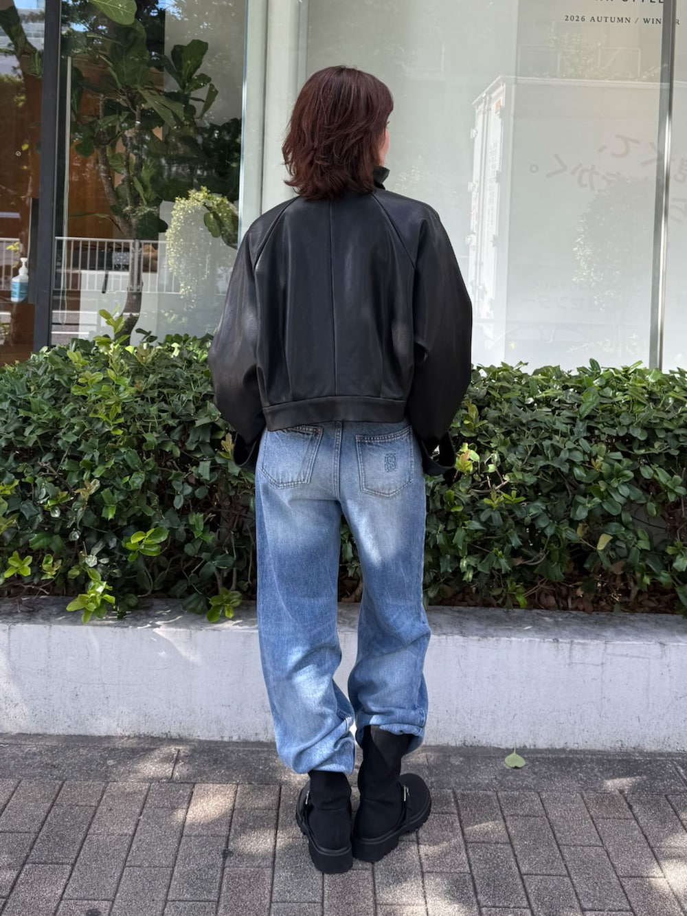 ブルー系のニット/セーター、ブラック系のブルゾン、ブルー系のデニムパンツを着用したレディースの秋コーディネートの7枚目の写真