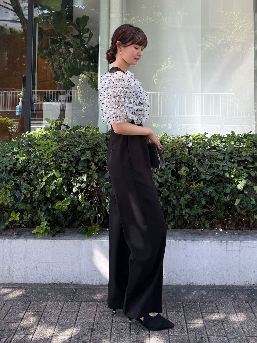 ブラック系のパンプス、その他のパンツドレス、シルバー系のピアス（両耳用）を着用したレディースの夏コーディネートの2枚目の写真