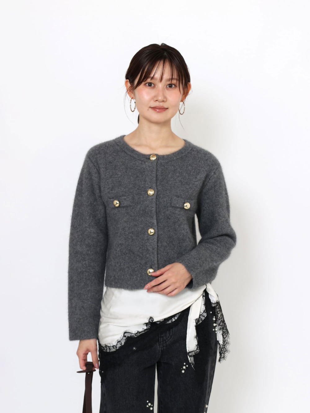 レッド系のブーツ、ブラウン系のハンドバッグ、ブラック系のデニムパンツを着用したレディースの秋コーディネートの4枚目の写真